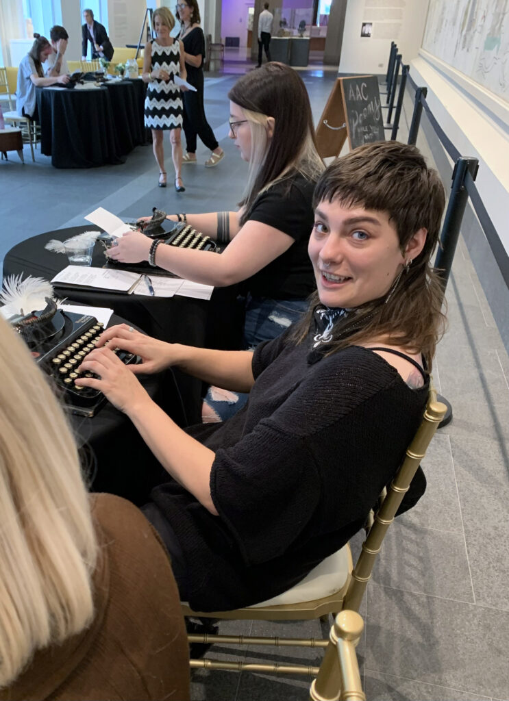 three students typing poems at event