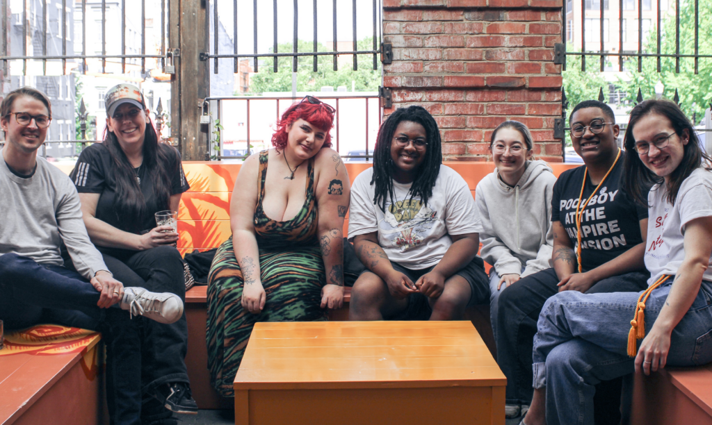 Several students sitting together on a bench, smiling at the camera