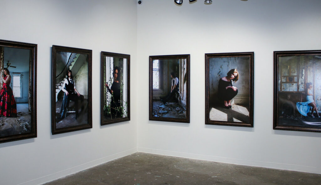 Several photo portraits in a gallery space.