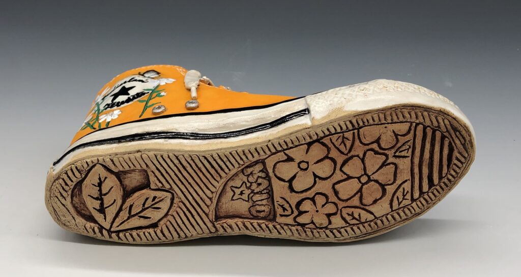 A ceramic shoe depicting floral elements