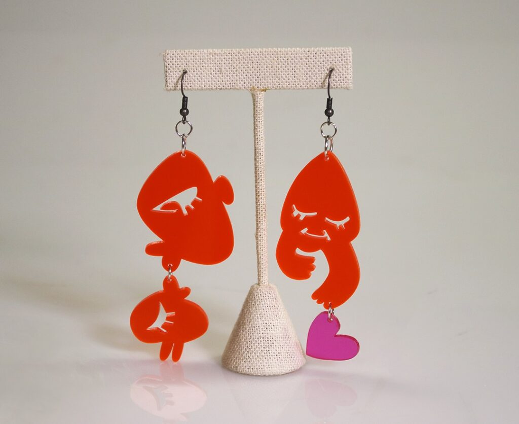 Plastic earrings that depict kissing faces