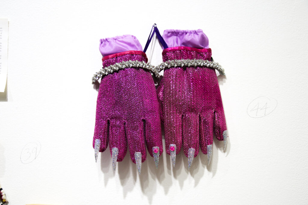 bedazzled pink gloves with tennis bracelets around hand created by artist Kyle Angel