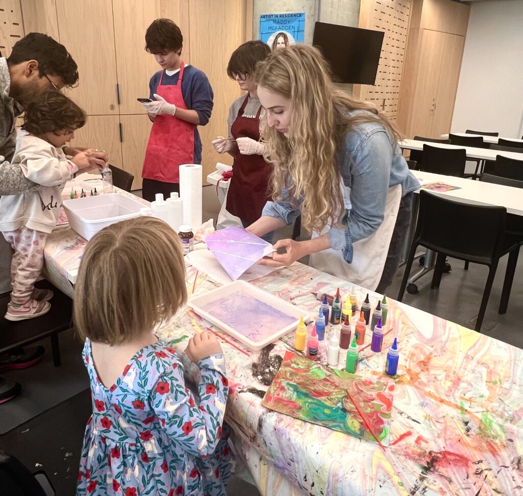 A photo of people helping children work on crafts